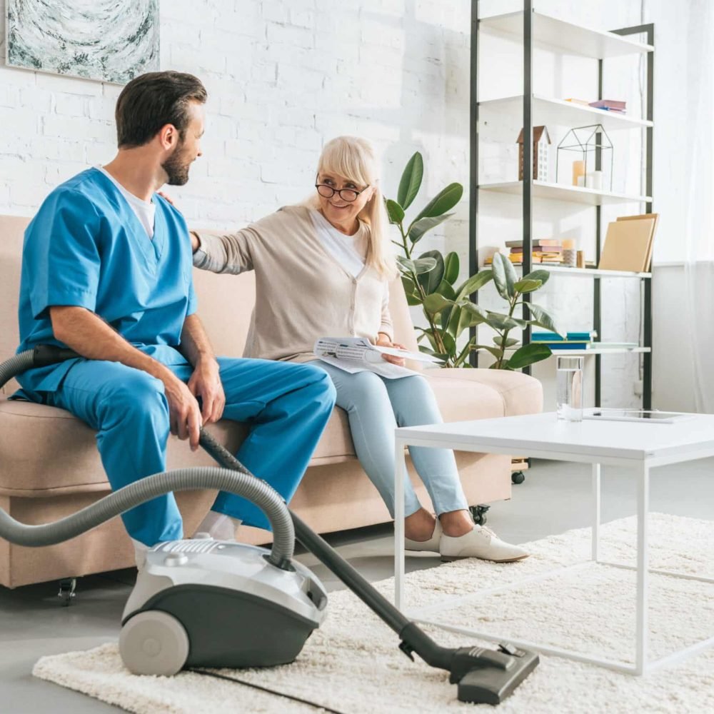 Smiling,Senior,Woman,Sitting,On,Couch,And,Looking,At,Social